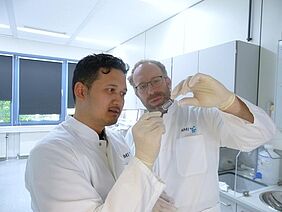 Tengku Ibrahim Maulana (links) und Prof. Peter Loskill, mit dem Chip, der Chancen eröffnet: Darauf lässt sich Tumorgewebe züchten, mit Zelltherapeutika behandeln und dann die Reaktion beobachten. Ein Schritt zu wirksameren und schonenderen Behandlungen | Copyright: Foto: NMI |