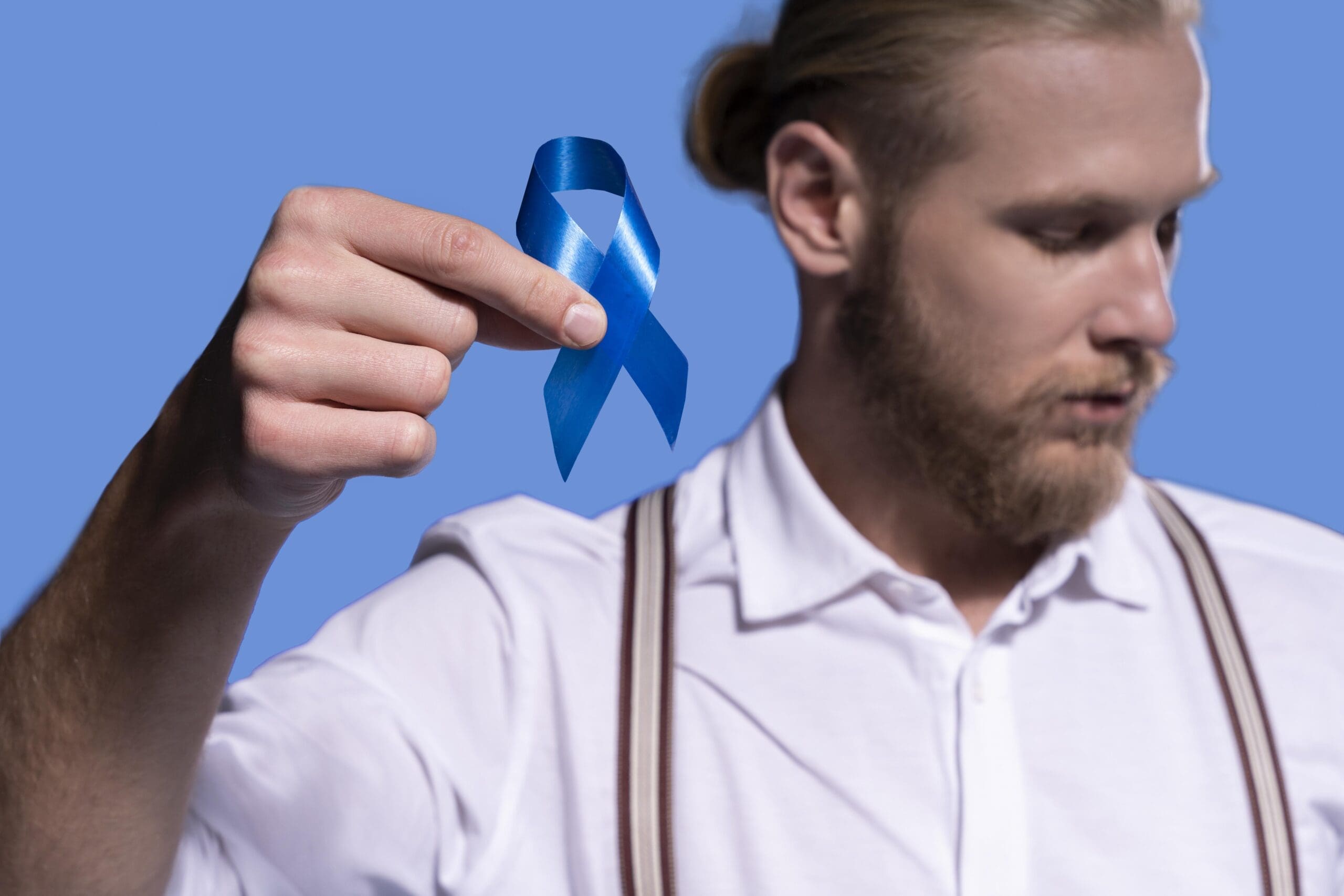 caucasian-man-holding-blue-ribbon